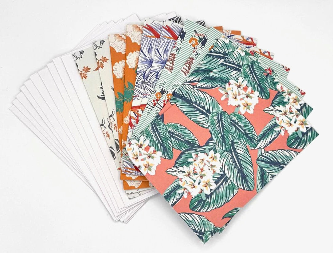 Ten multi-colored notecards by Makanalani with five different tropical prints (two of each print) with their solid white envelopes