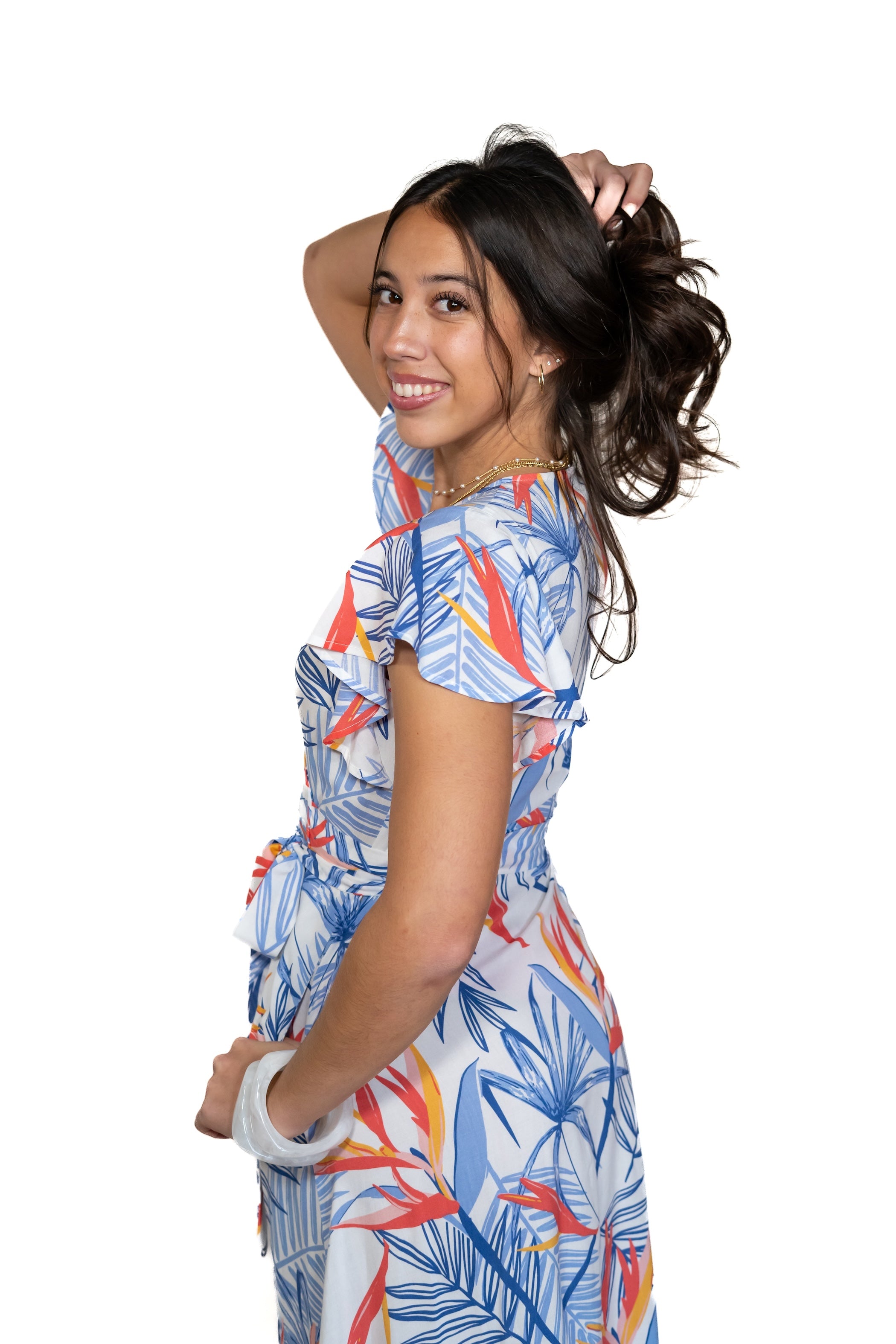 Woman wearing a colorful bird of paradise printed dress with a white background