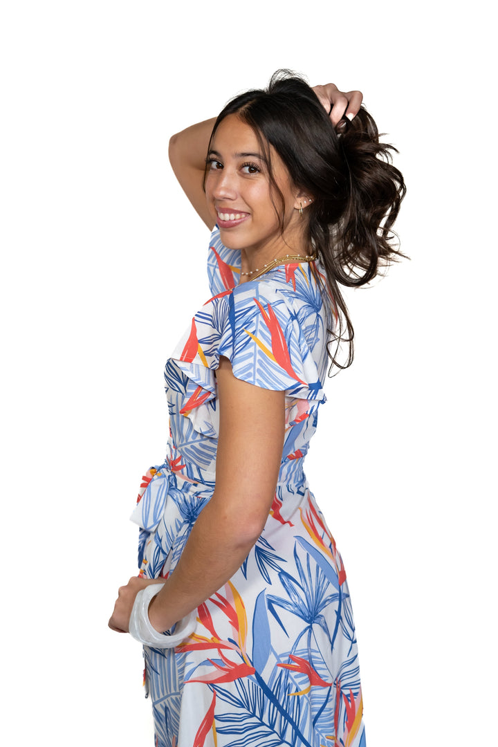 Woman wearing a colorful bird of paradise printed dress with a white background