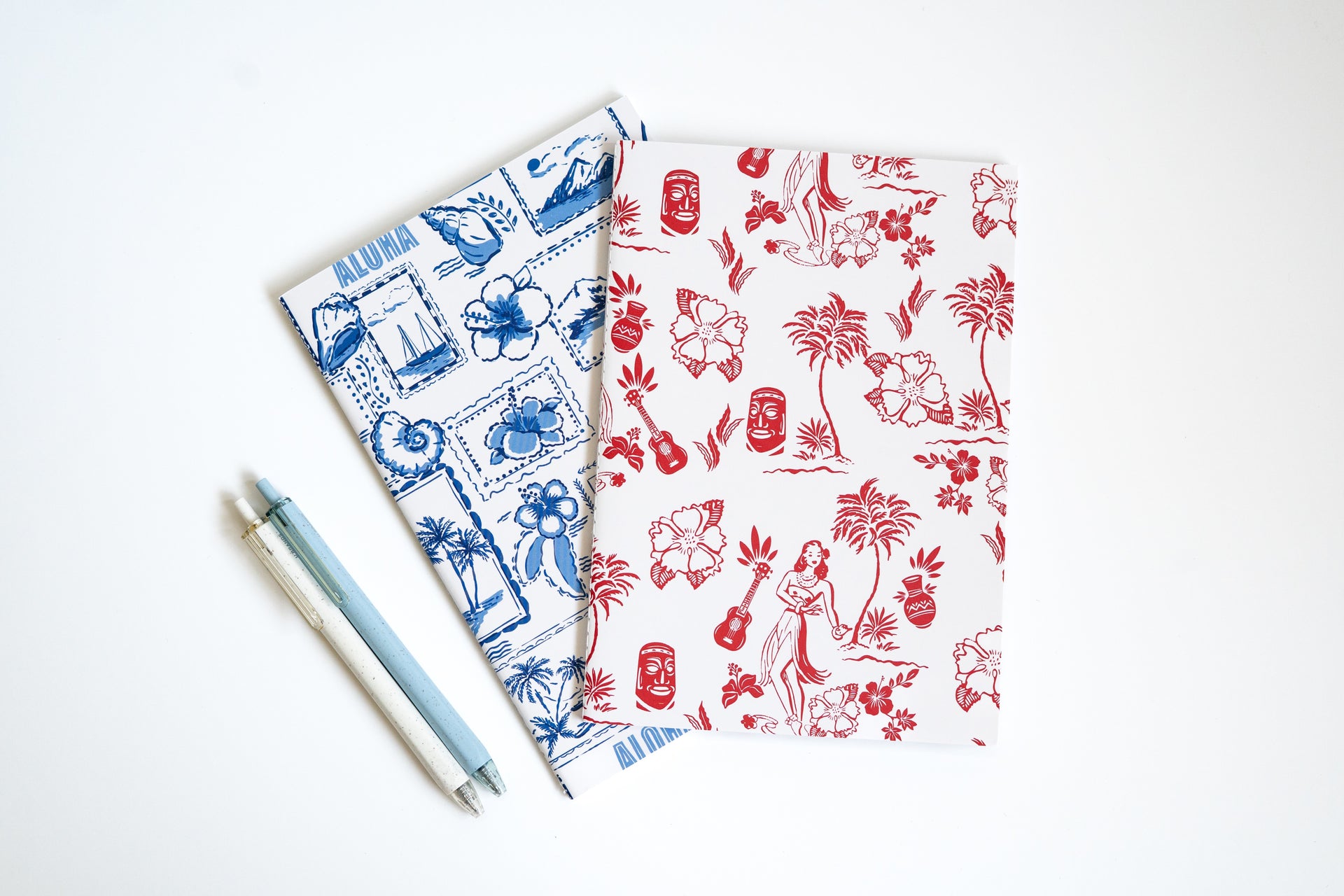Two notebooks with tropical patterns on a white background