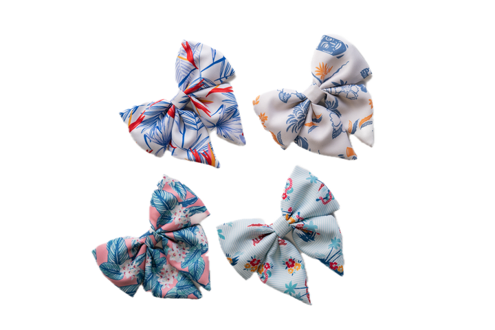 Four multi-colored bows with tropical prints for a dog collar
