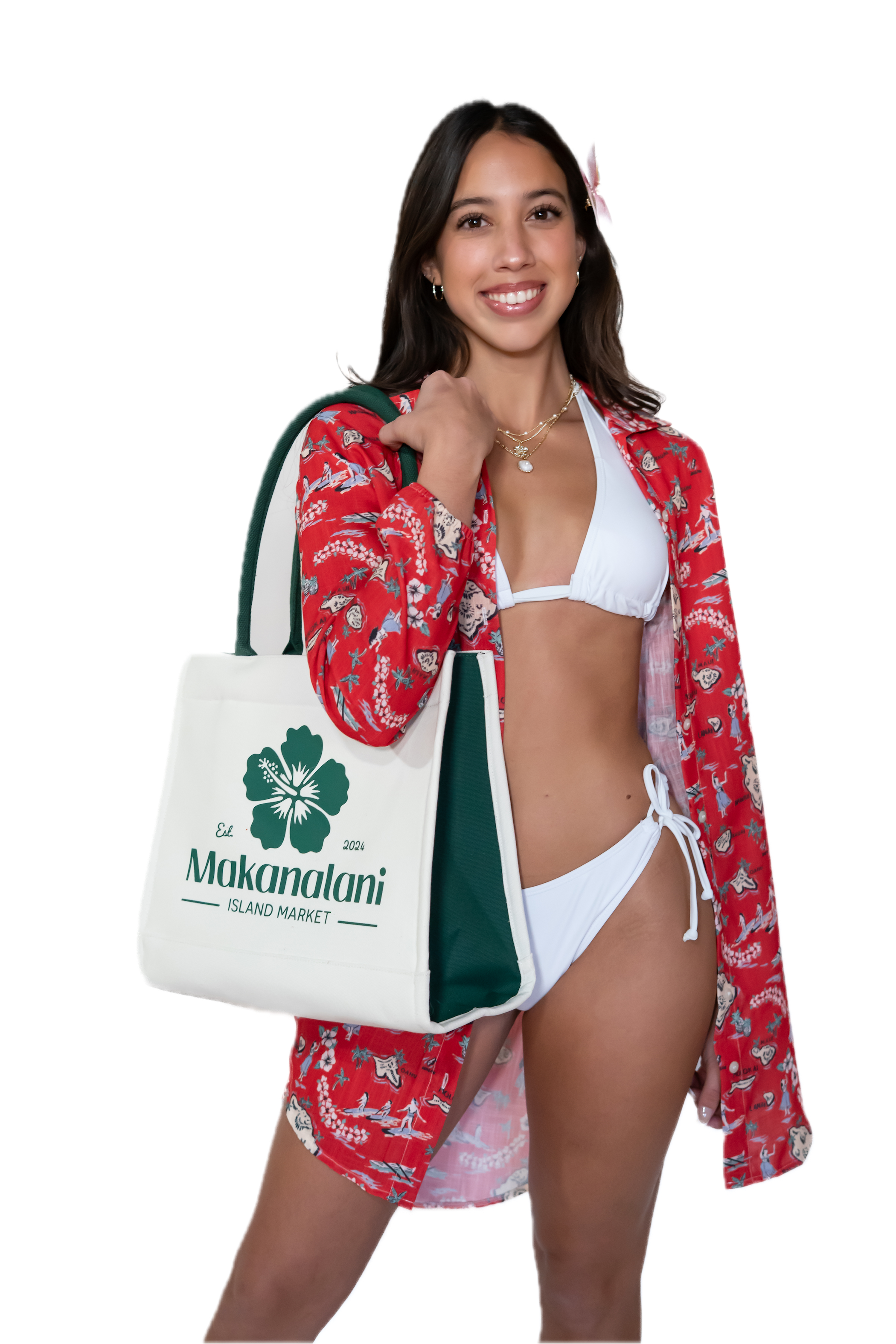 Woman in a red floral cover-up holding a Makanalani tote bag on a white background