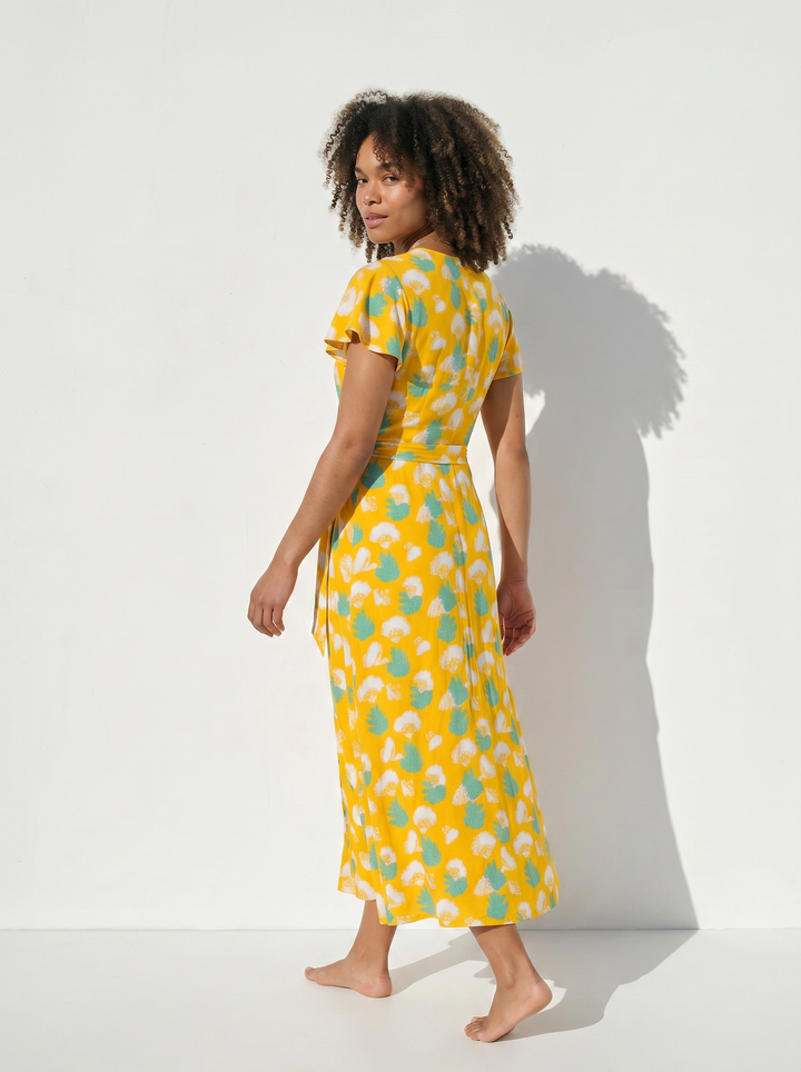 Back view of  yellow gingko print wrap dress on a white background