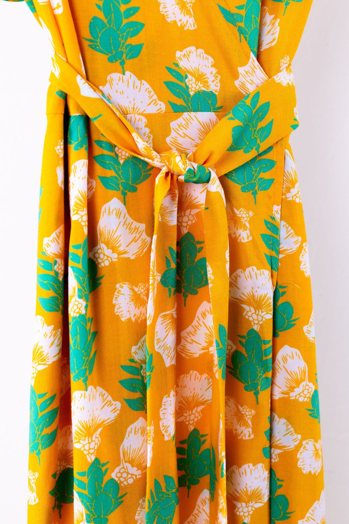 Yellow dress with green floral pattern on a white background