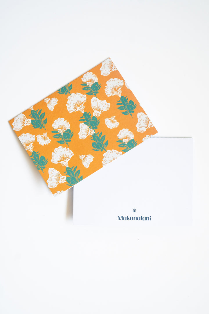 Multi-colored notecard by Makanalani with yellow background and green and white gingko leaves and flowers