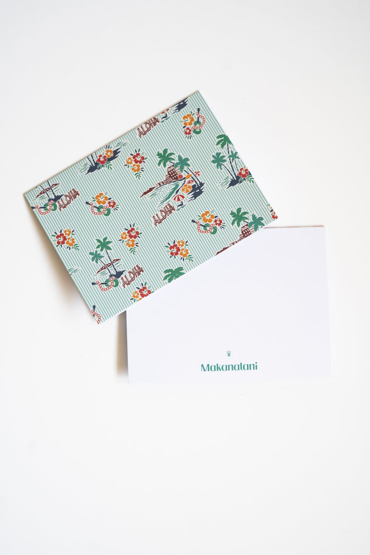 Multi-colored notecard by Makanalani with green stripes and a hotel on a beach on a white background