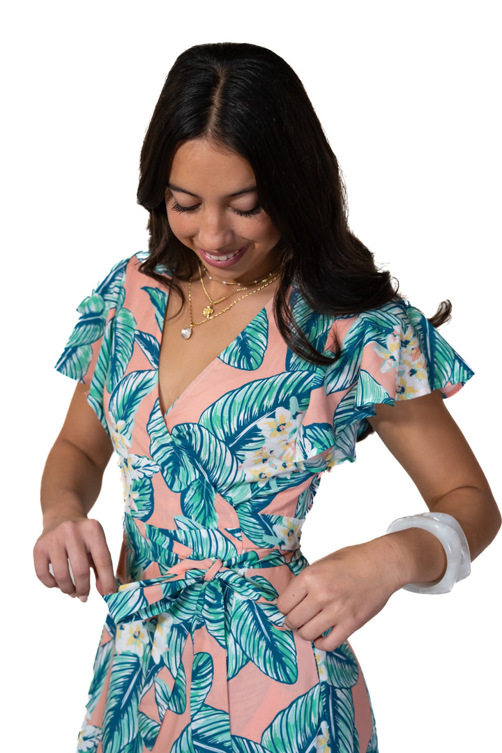 Woman wearing a tropical leaf patterned dress on a white background