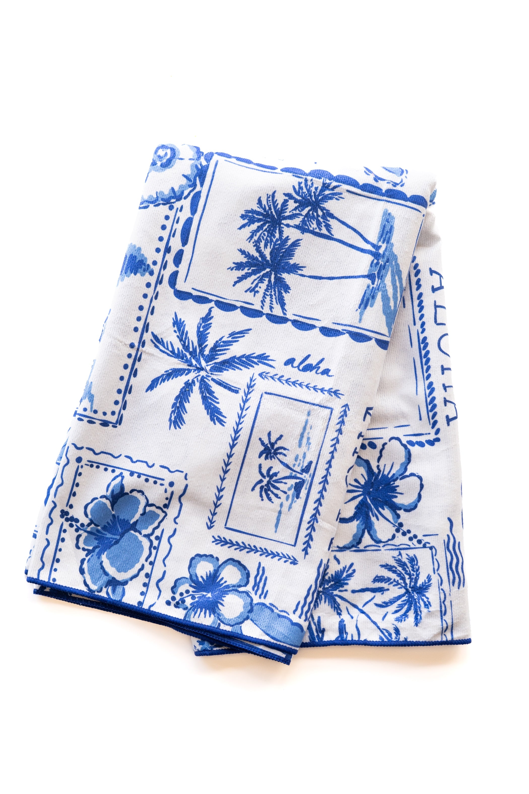 White towel with blue floral and palm tree patterns on a white background