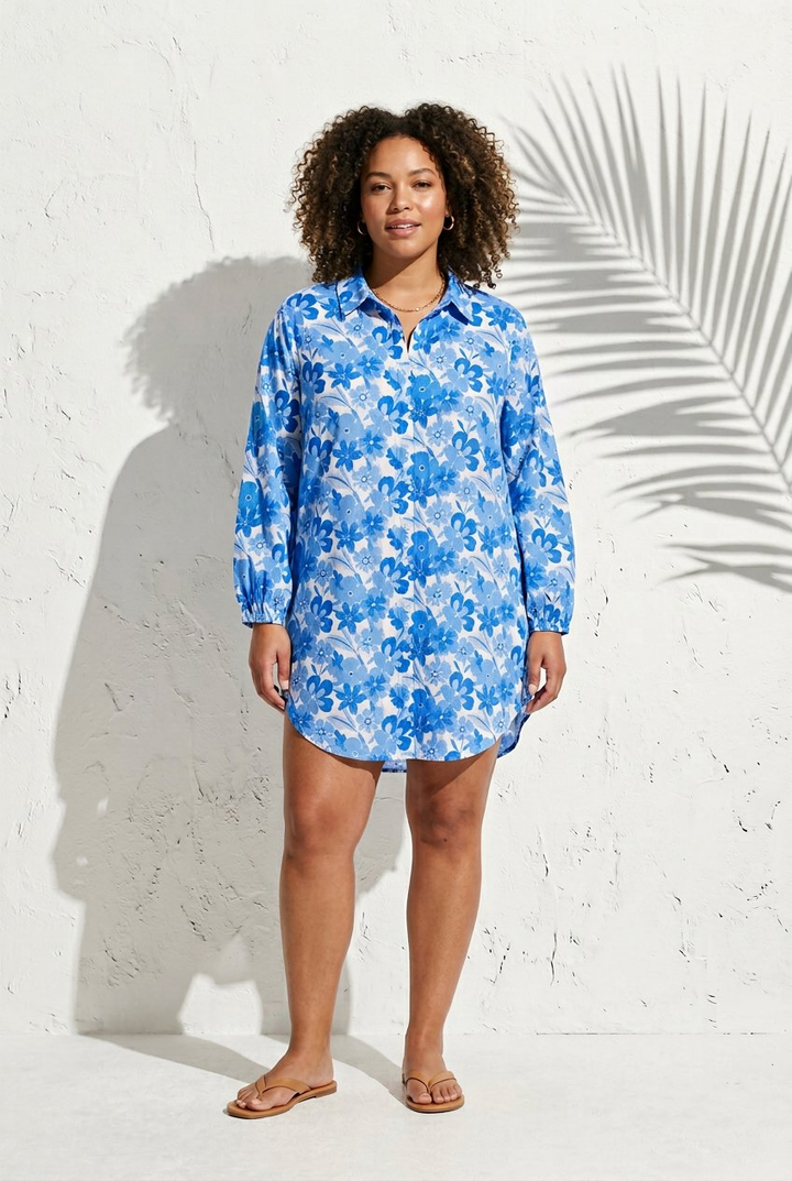 Woman wearing a blue floral swim cover-up against a white background